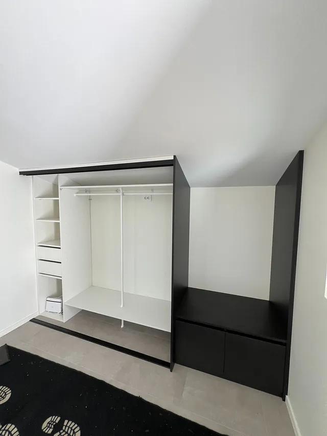 Garderobe i sort og hvitt med åpne seksjoner og plass til oppbevaring.