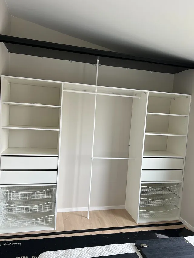 Stor garderobe med hyller, skuffer, trådkurver og stenger for oppheng.